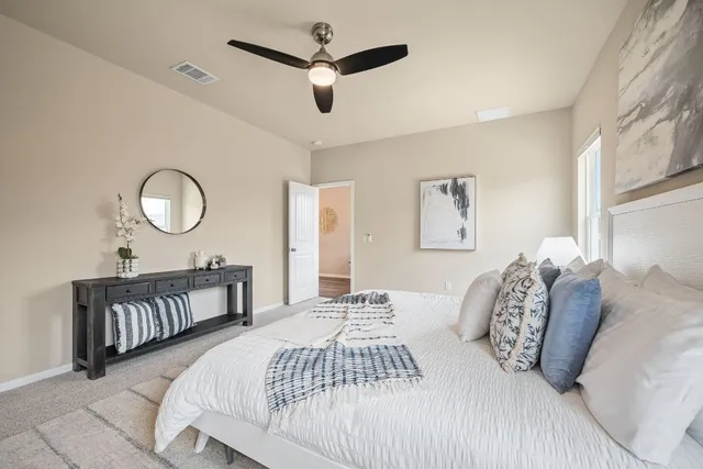 a bedroom with a bed ceiling fan and a window