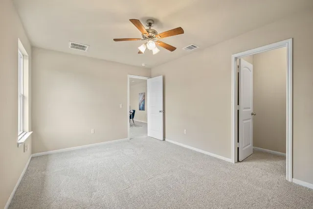 a view of an empty room with a ceiling fan