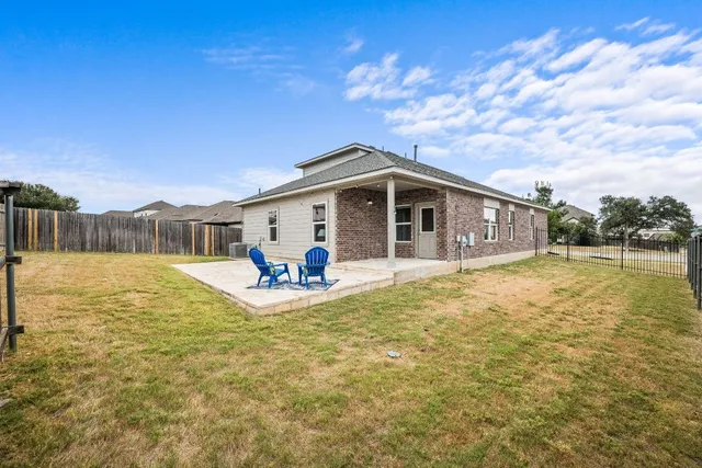 a view of a house with backyard and sitting area