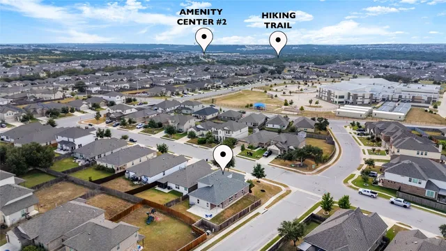 an aerial view of a city with lots of residential buildings ocean and mountain view in back
