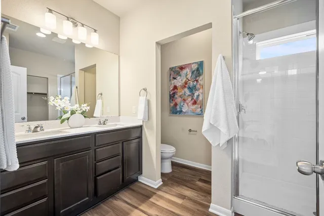 a bathroom with a double vanity sink toilet and shower