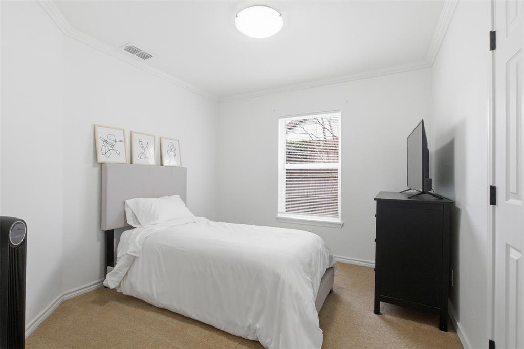 9112 Shiloh Road Dallas, TX 75228 - Photo 15 of 23 a bedroom with a bed and a flat tv screen on a dresser
