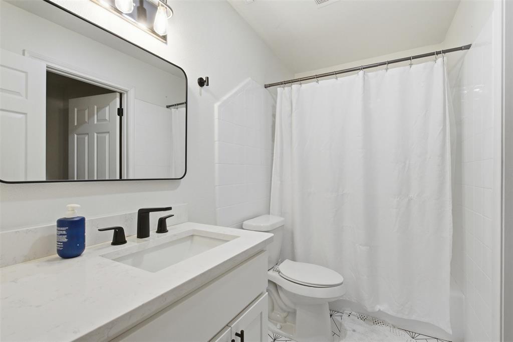 9112 Shiloh Road Dallas, TX 75228 - Photo 17 of 23 a bathroom with a sink a toilet and a mirror