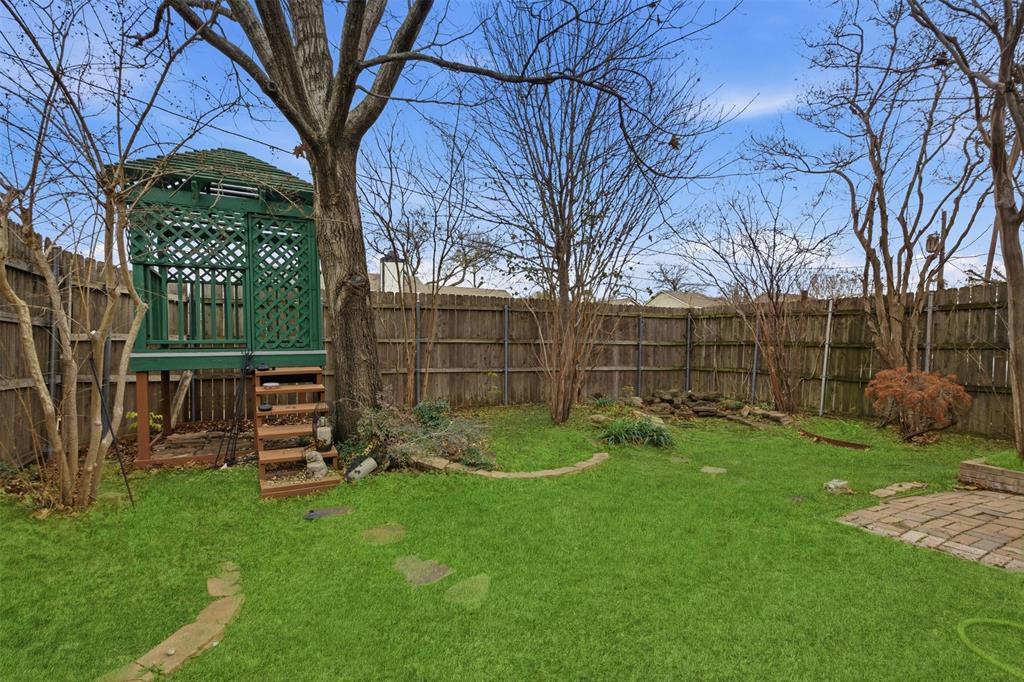 9112 Shiloh Road Dallas, TX 75228 - Photo 22 of 23 a view of backyard with wooden fence and a large tree