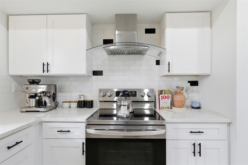 9112 Shiloh Road Dallas, TX 75228 - Photo 8 of 23 a kitchen with a stove and white cabinets