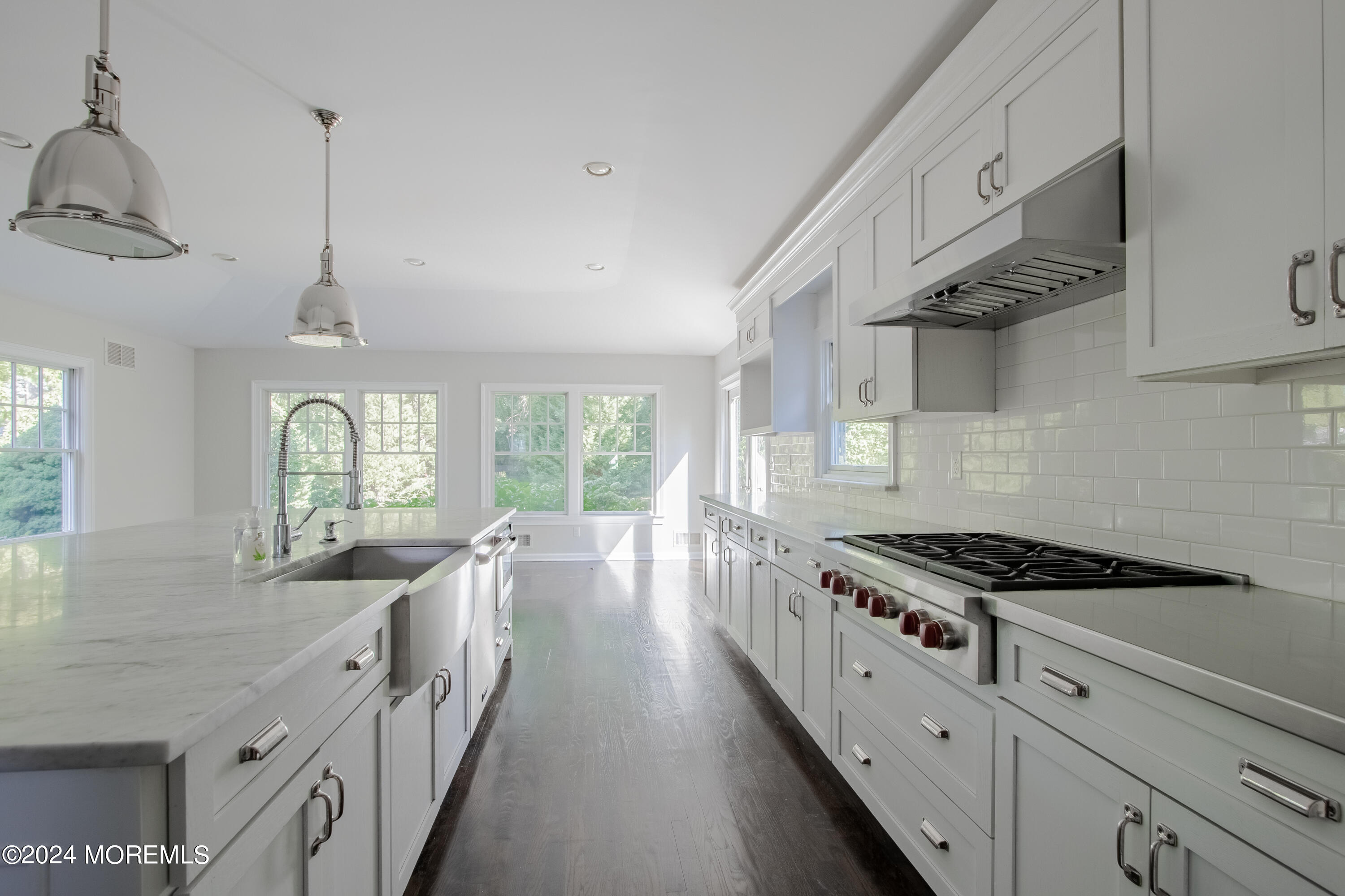 67 Rivers Edge Drive Little Silver, NJ 07739 - Photo 5 of 40 a kitchen with stainless steel appliances granite countertop a stove a sink dishwasher and white cabinets with wooden floor