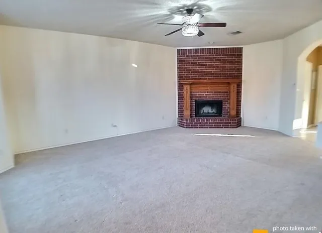 a view of a livingroom with a fireplace and chandelier fan