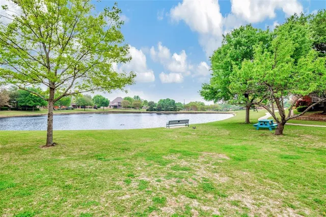 a view of a lake with a big yard and large trees