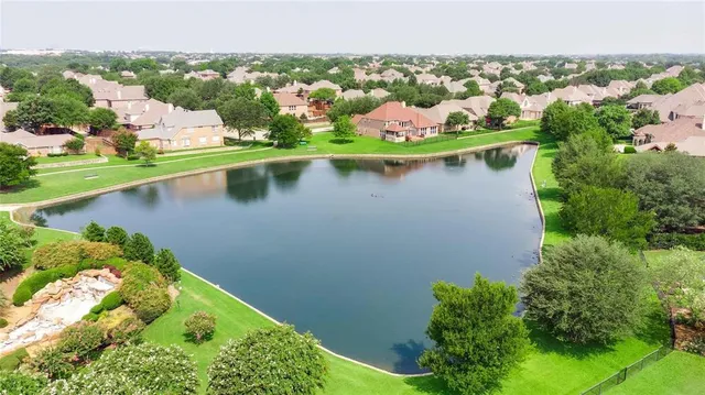 an aerial view of residential houses with outdoor space and lake view