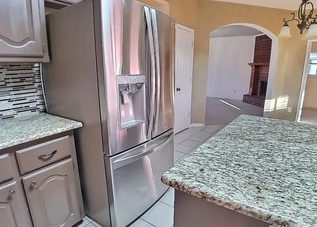 a kitchen with kitchen island a counter top space and refrigerator