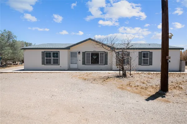 a front view of a house with a dirt yard