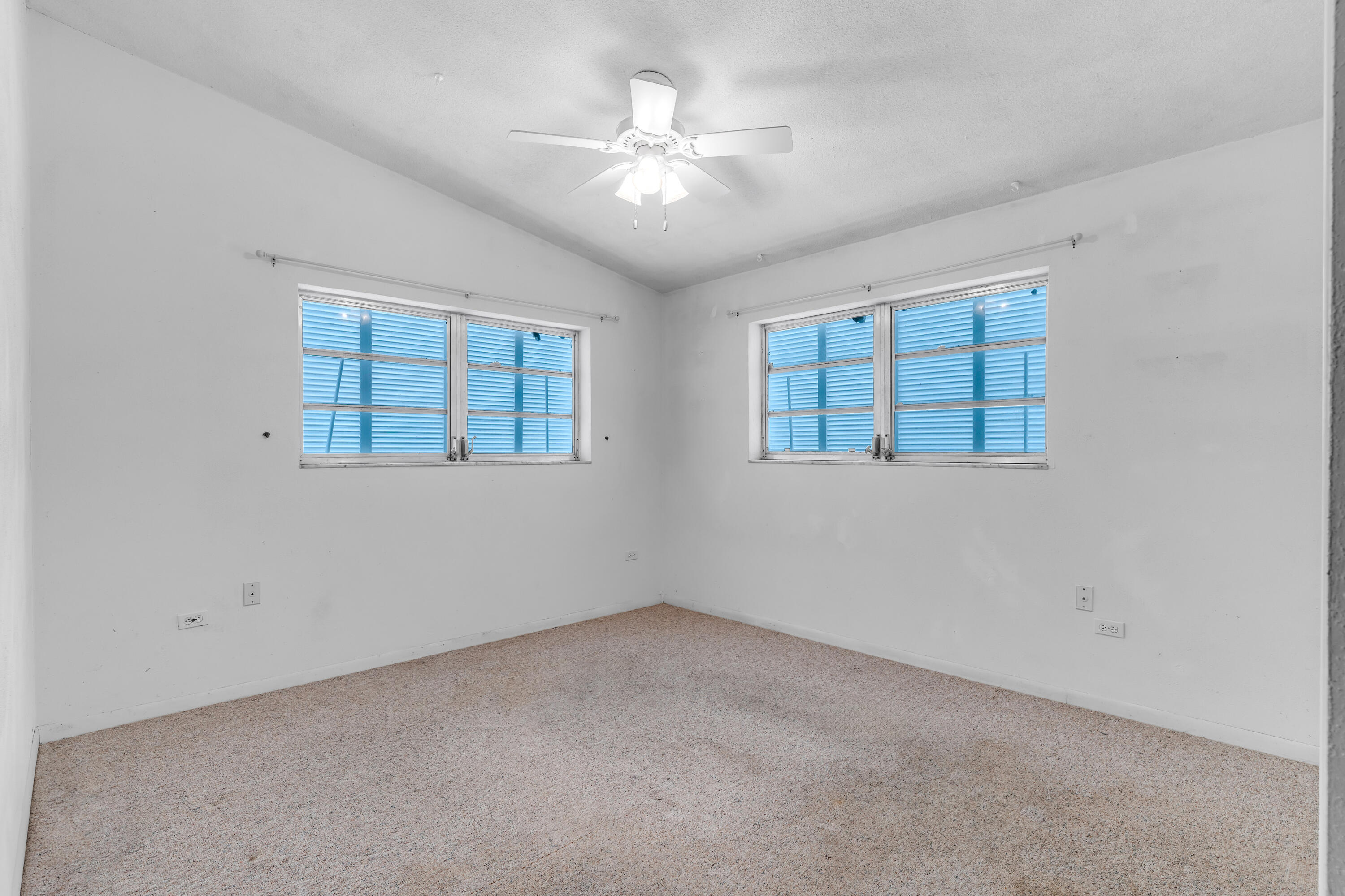 1502 Shaw Drive Key Largo, FL 33037 - Photo 23 of 42 an empty room with chandelier fan and windows
