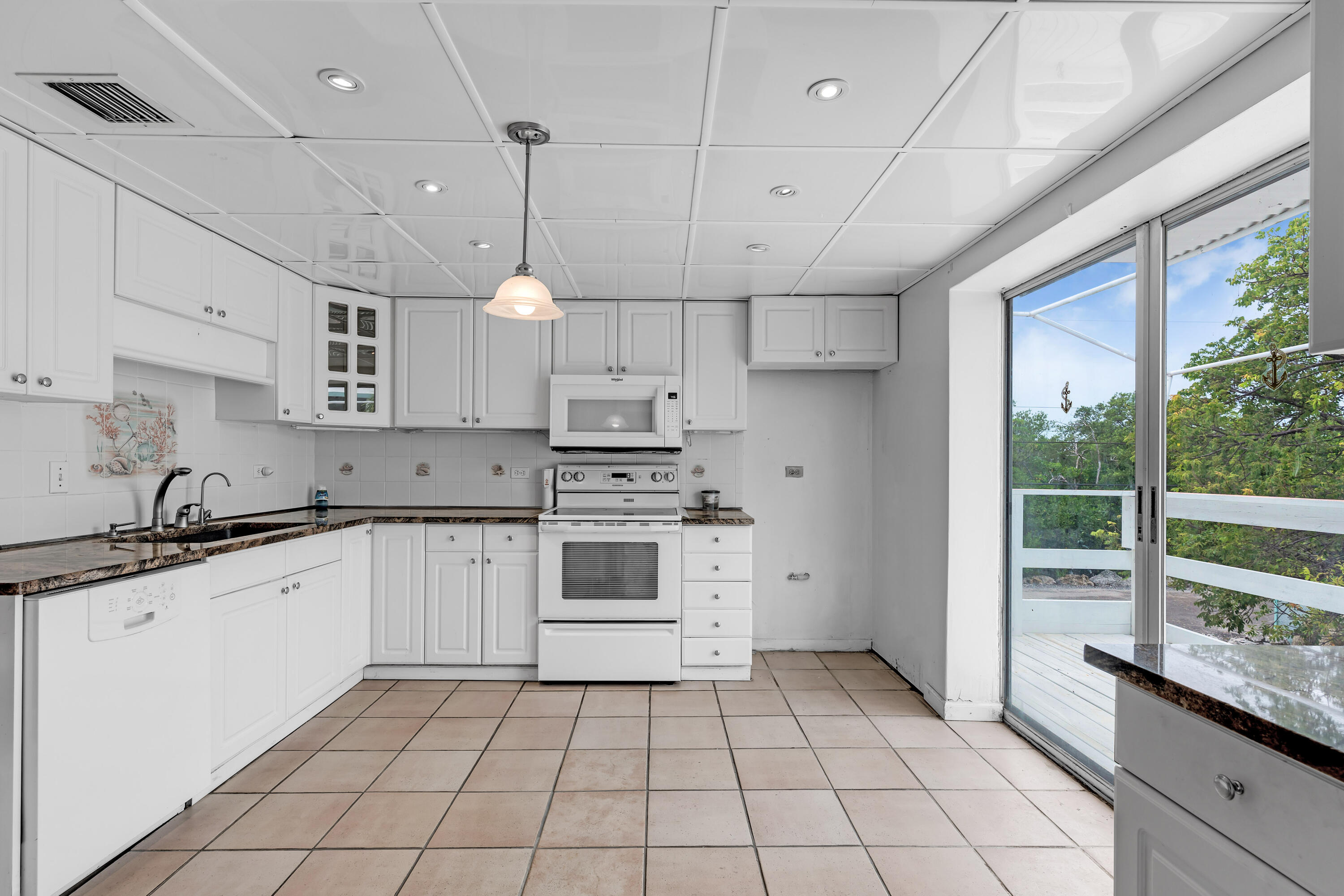 1502 Shaw Drive Key Largo, FL 33037 - Photo 6 of 42 a kitchen with a sink a stove a refrigerator and cabinets
