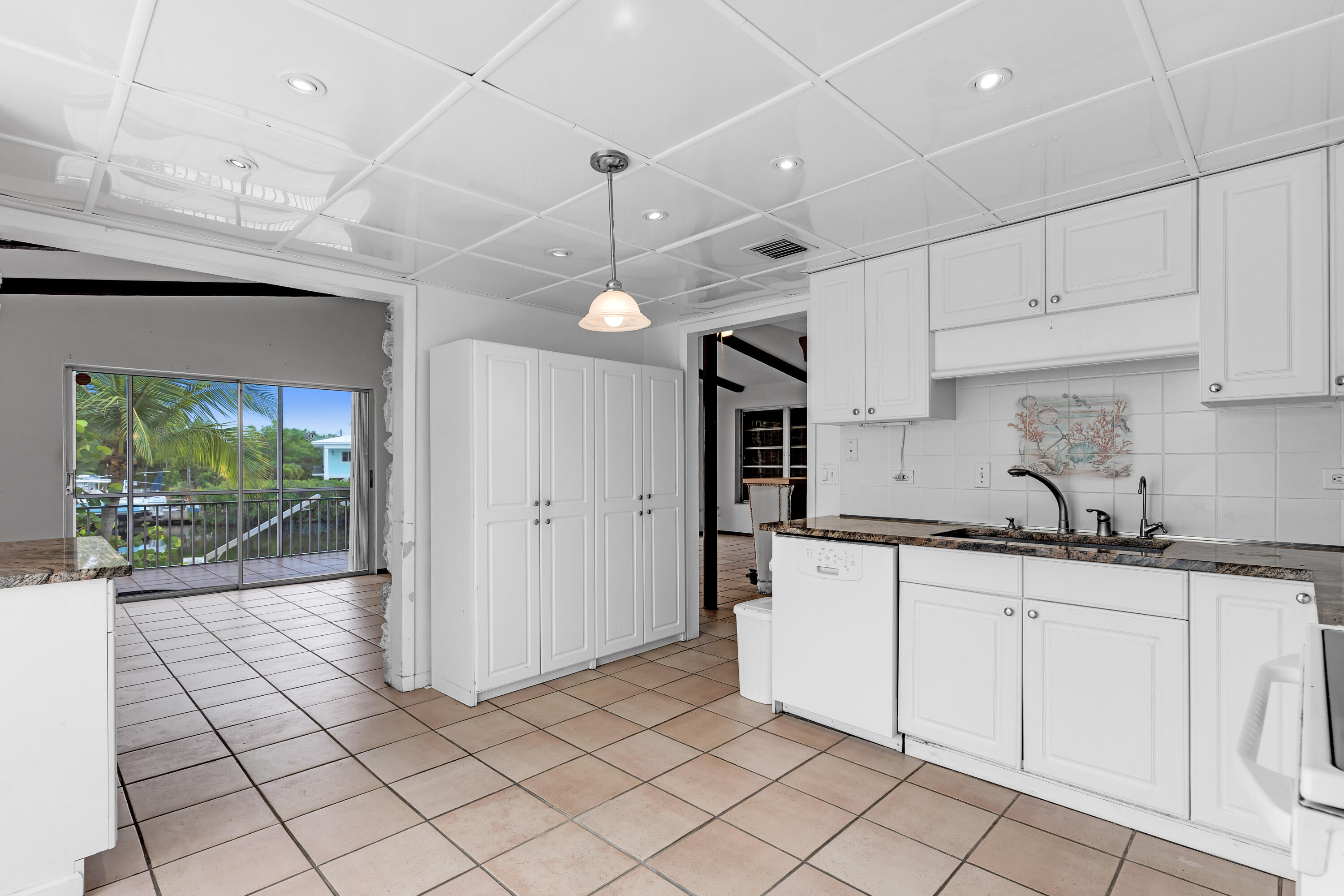 1502 Shaw Drive Key Largo, FL 33037 - Photo 7 of 42 a kitchen with granite countertop white cabinets and white appliances