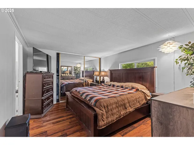 a bedroom with bed and wooden floor