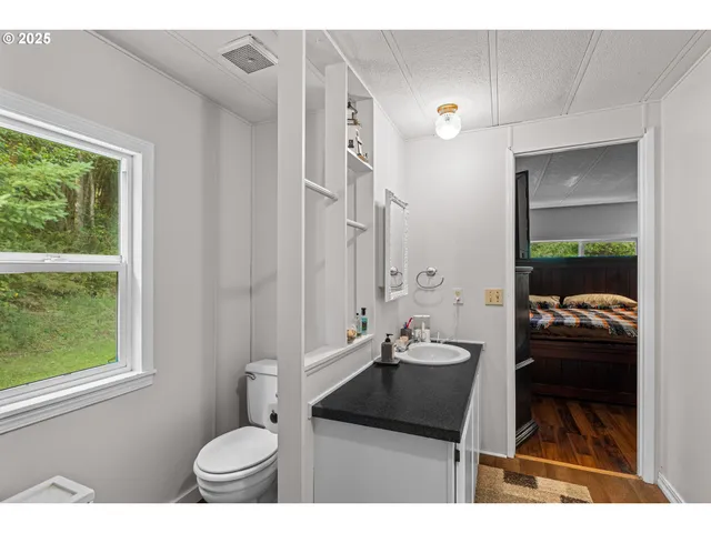 a bathroom with a sink vanity granite and toilet