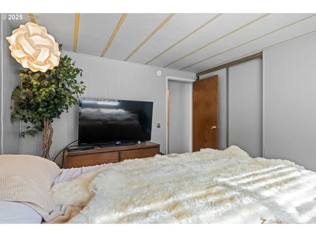a bedroom with a bed and a flat screen tv