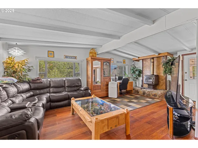a living room with furniture a flat screen tv and a floor to ceiling window