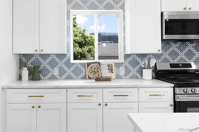 a kitchen with stainless steel appliances granite countertop a sink a stove and a microwave