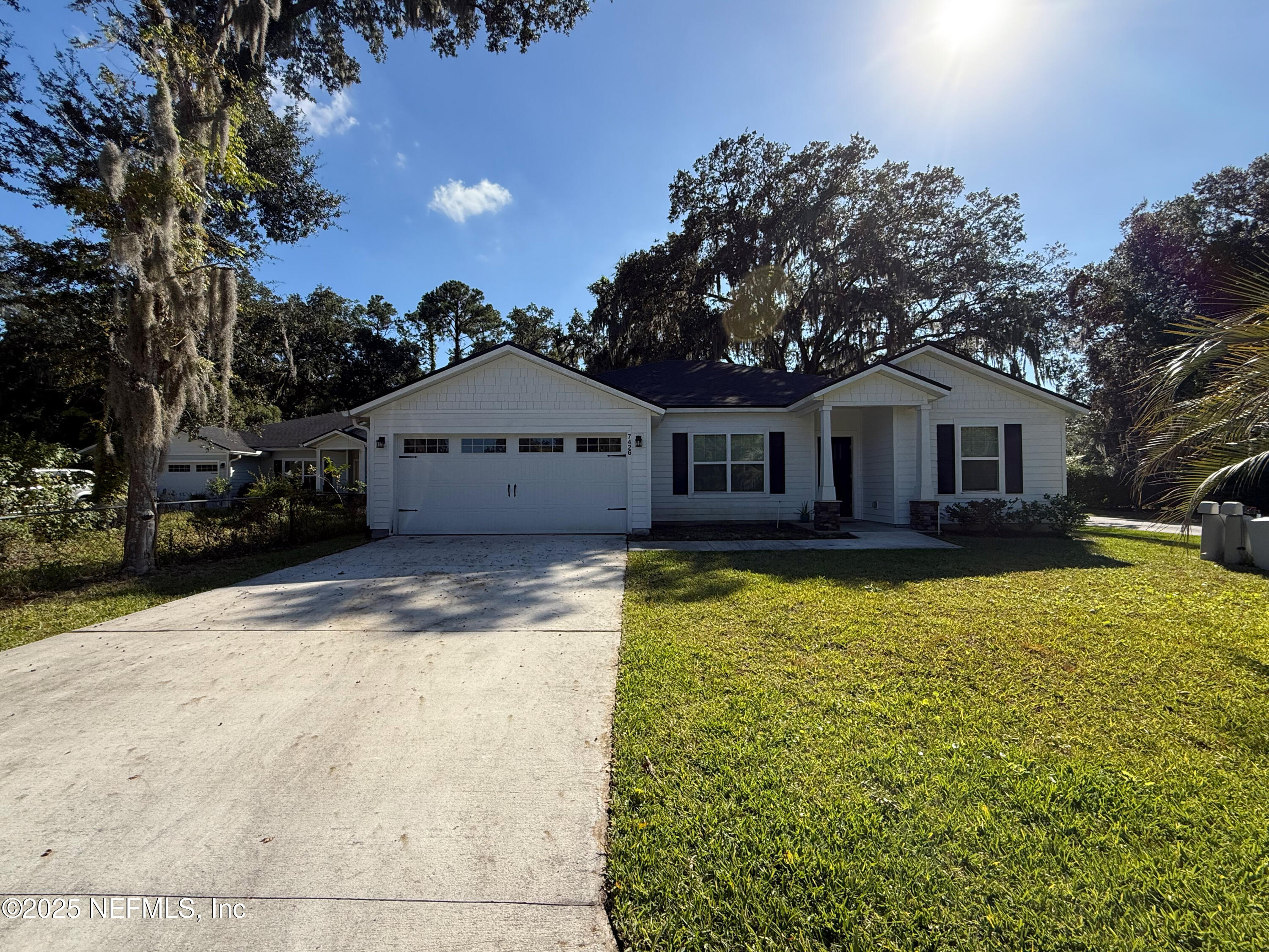 a front view of a house with yard patio and tree