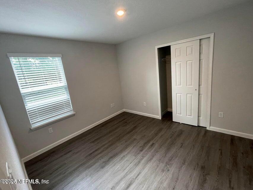 7426 Bowden Road Jacksonville, FL 32216 - Photo 11 of 23 a view of an empty room with wooden floor and a window