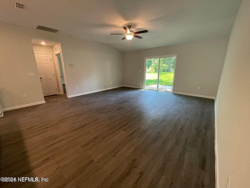 7426 Bowden Road Jacksonville, FL 32216 - Photo 12 of 23 a view of empty room with wooden floor and fan