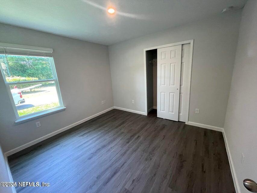 7426 Bowden Road Jacksonville, FL 32216 - Photo 13 of 23 an empty room with wooden floor and windows