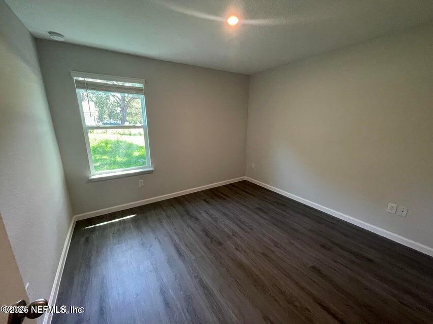 7426 Bowden Road Jacksonville, FL 32216 - Photo 16 of 23 an empty room with wooden floor and windows