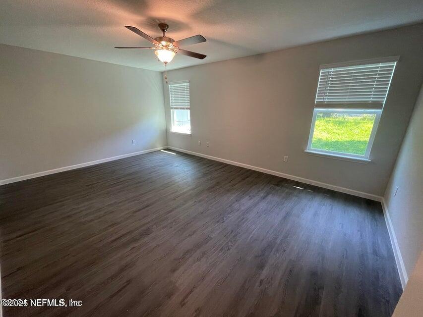 7426 Bowden Road Jacksonville, FL 32216 - Photo 17 of 23 an empty room with wooden floor and windows
