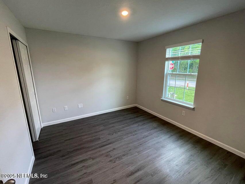 7426 Bowden Road Jacksonville, FL 32216 - Photo 4 of 23 an empty room with wooden floor and windows