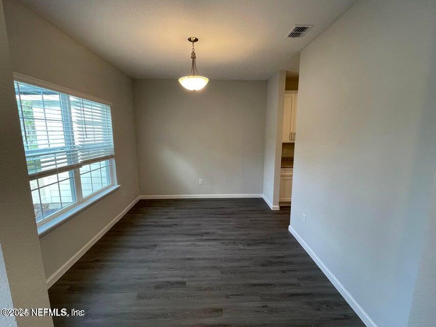 7426 Bowden Road Jacksonville, FL 32216 - Photo 5 of 23 a view of an empty room with wooden floor and a window