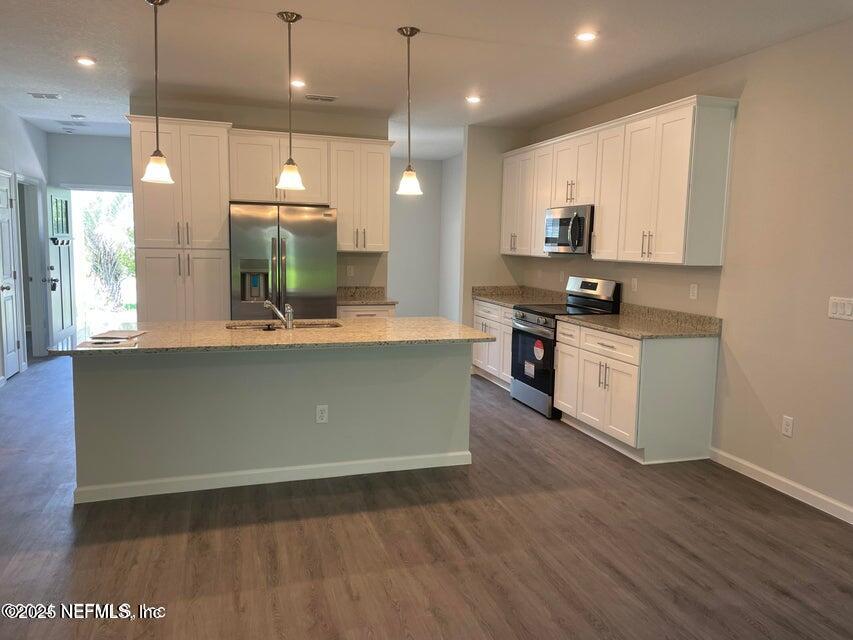 7426 Bowden Road Jacksonville, FL 32216 - Photo 7 of 23 a large kitchen with stainless steel appliances a large counter top a stove a sink dishwasher and a refrigerator