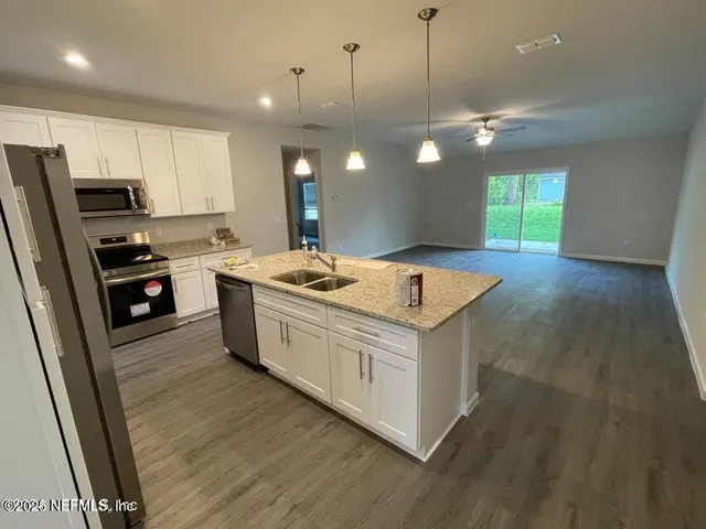 a kitchen with a stove window and wooden floor