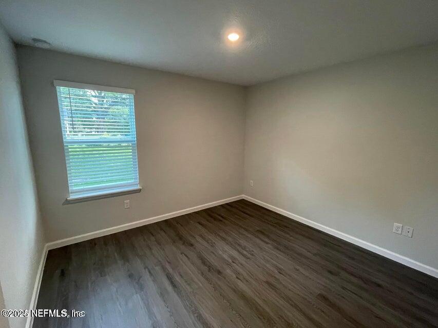 7426 Bowden Road Jacksonville, FL 32216 - Photo 10 of 23 a view of an empty room with wooden floor and a window