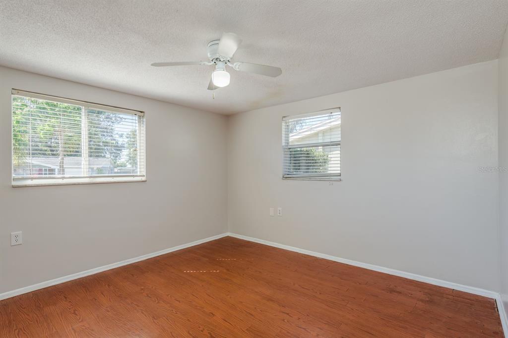 1748 Colmar Drive Holiday, FL 34690 - Photo 18 of 29 an empty room with wooden floor and windows