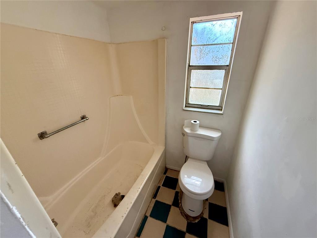 1134 Engman Street Clearwater, FL 33755 - Photo 13 of 27 a bathroom with a toilet a sink and a window