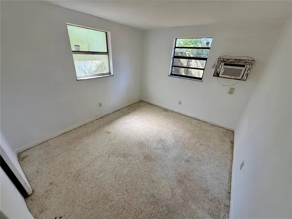 an empty room with windows and closet