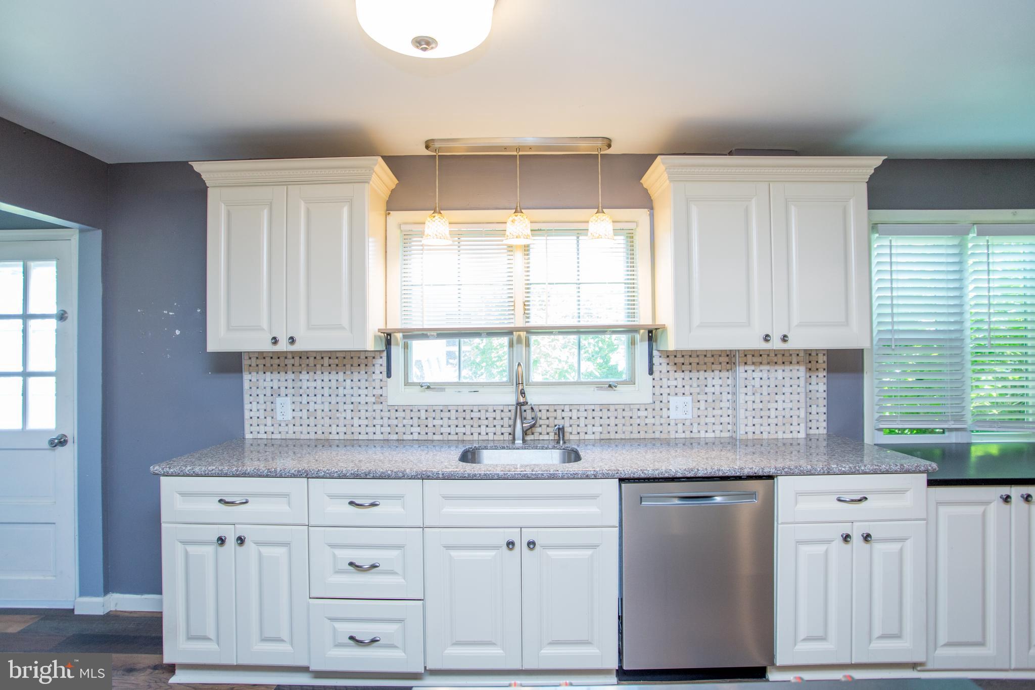 105 Wilson Avenue Hellertown, PA 18055 - Photo 18 of 46 a kitchen with granite countertop white cabinets white appliances and a sink