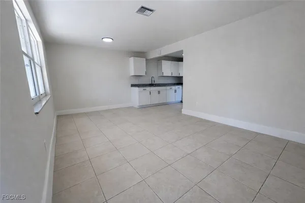 an empty room with cabinet and windows