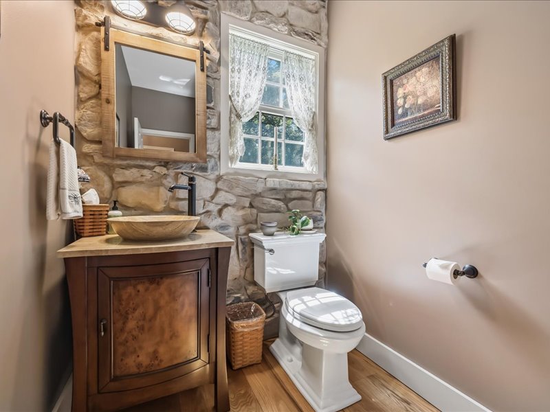 1168 Mt Pleasant Road Bangor, PA 18013 - Photo 58 of 100 Natural stone accent walls and rich wood floors bring rustic character to this powder room.