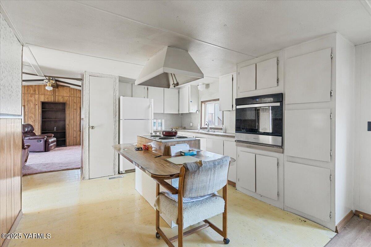100 Gordon Lane Wapato, WA 98951 - Photo 14 of 19 a kitchen with white cabinets and stainless steel appliances