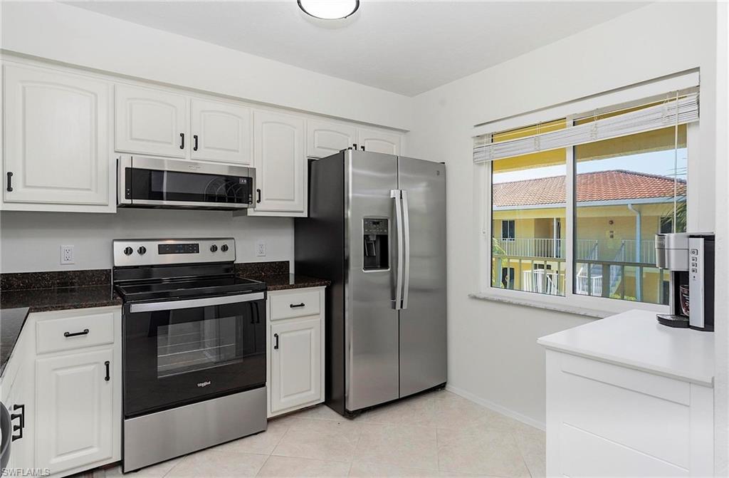 1001 Foxfire Lane, Unit 307 Naples, FL 34104 - Photo 2 of 23 a kitchen with stainless steel appliances a stove a microwave and a sink