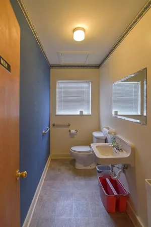 a bathroom with a toilet a sink and mirror