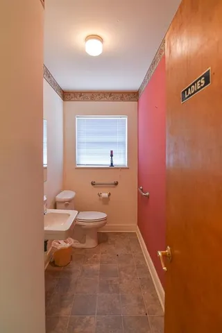 a bathroom with a toilet a sink and mirror