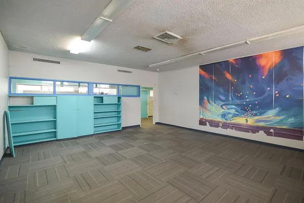 a view of an empty room with wooden floor and windows