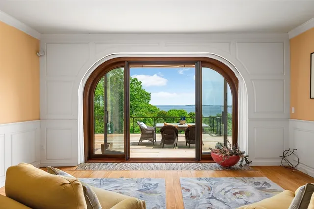 a living room with a balcony a couch and a potted plant