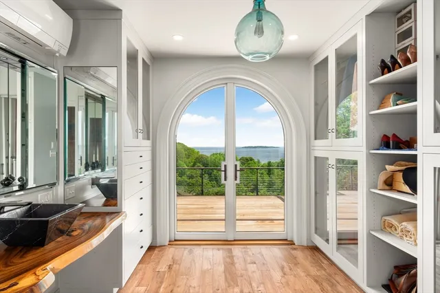 a large kitchen with stainless steel appliances wooden floor and a large window