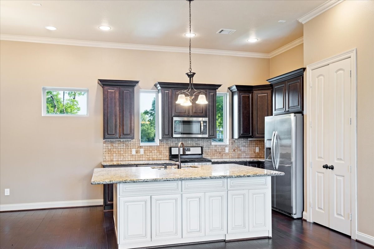1516 Amundsen Street Houston, TX 77009 - Photo 12 of 32 a kitchen with stainless steel appliances granite countertop a refrigerator a sink dishwasher a oven and a dining table with wooden floor