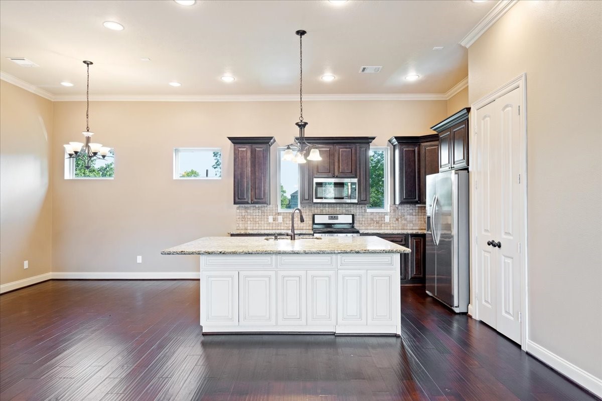 1516 Amundsen Street Houston, TX 77009 - Photo 13 of 32 a kitchen with stainless steel appliances granite countertop a sink a stove and refrigerator