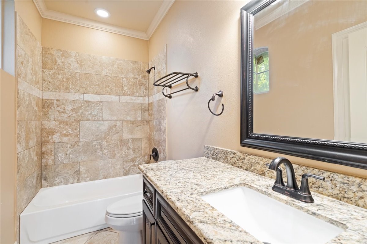 1516 Amundsen Street Houston, TX 77009 - Photo 28 of 32 a bathroom with a granite countertop sink a toilet a mirror and bathtub